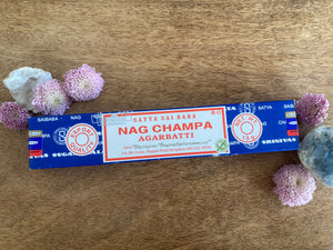 Box of Nag Champa incense with flowers on a wooden surface